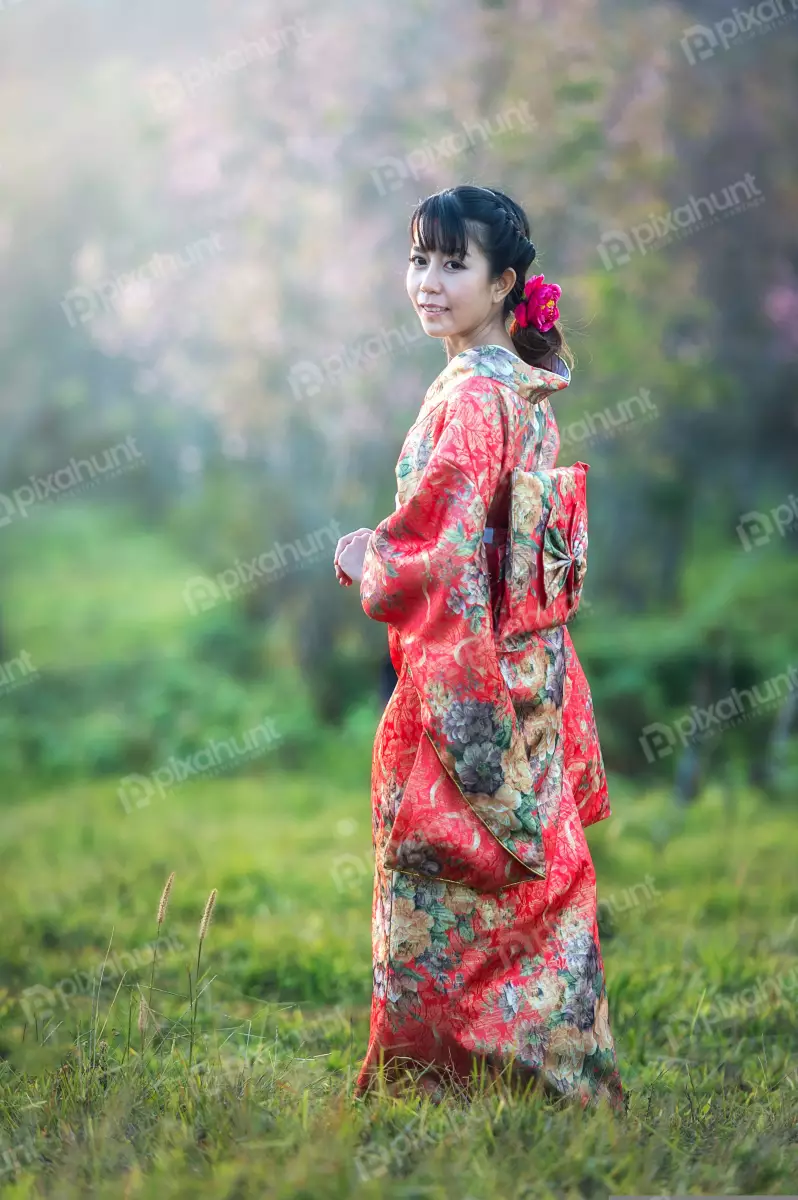 Free Premium Stock Photos A beautiful woman wearing a traditional Japanese kimono and long black hair is tied in a bun and she has a pink flower in her hair