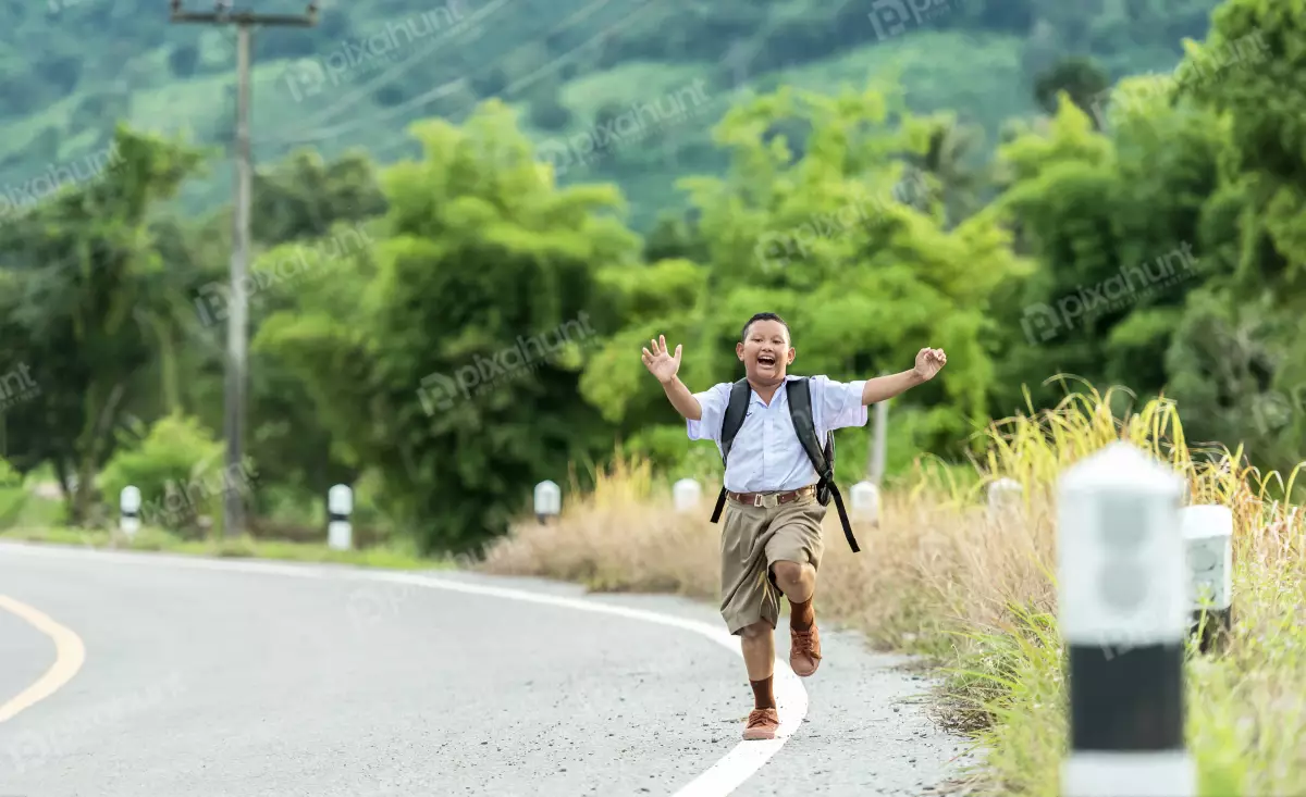 Free Premium Stock Photos A boy running down a road and wearing a school uniform and has a backpack on his back