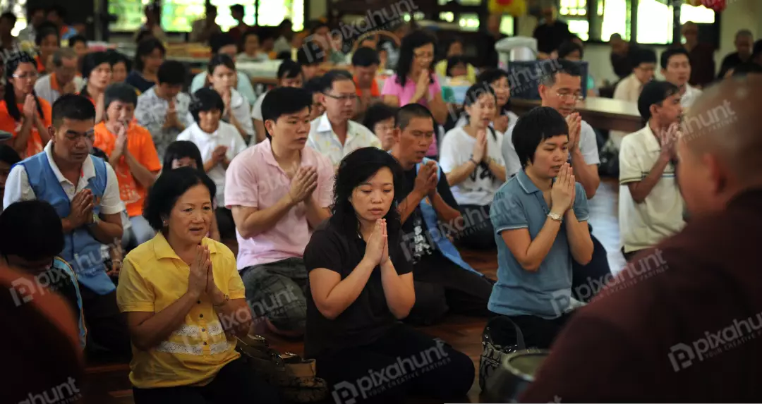 Free Premium Stock Photos A group of people sitting on the floor with their hands together in a prayer position