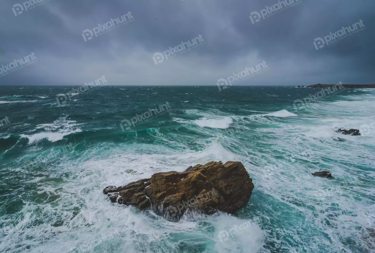 Free Premium Stock Photos a large rock in the middle of the ocean