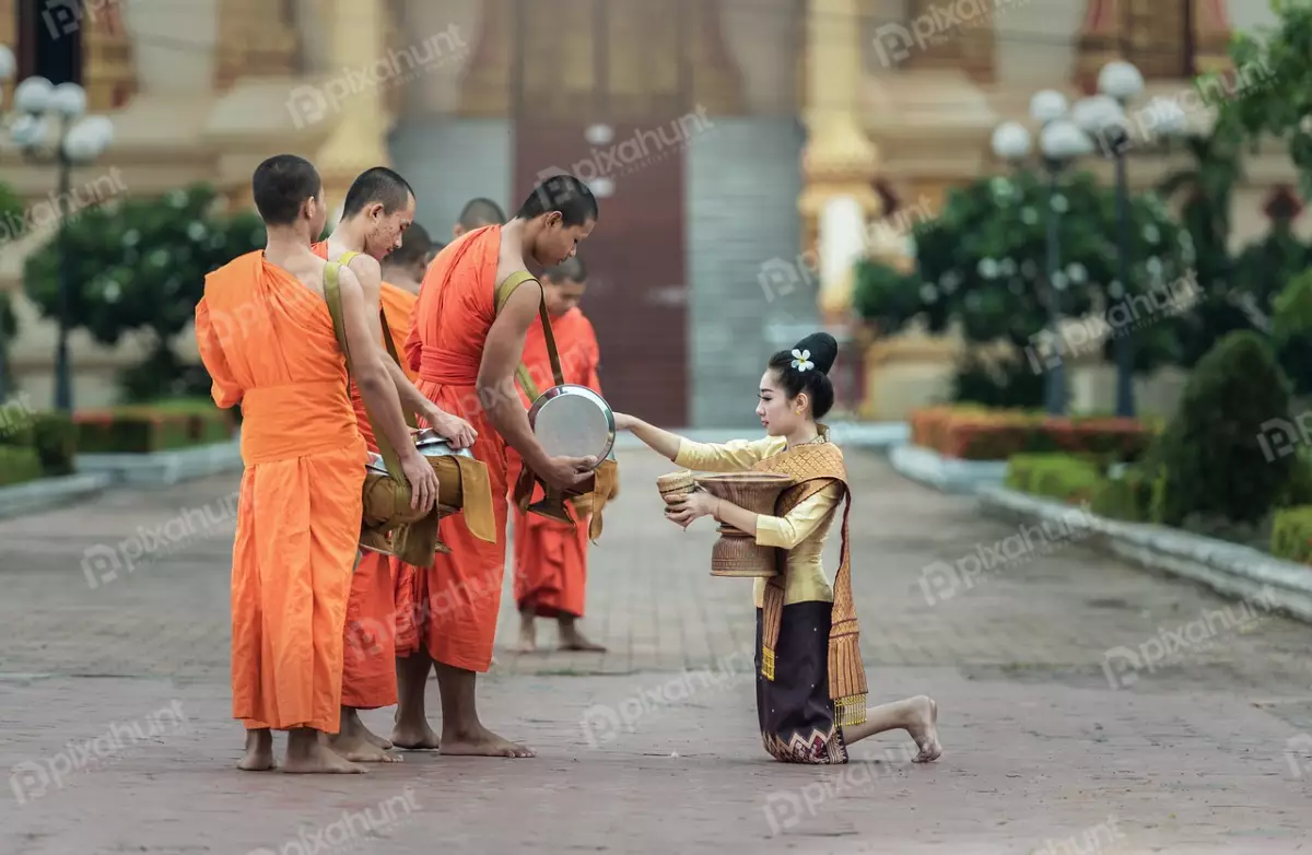 Free Premium Stock Photos A portrayal of a scene that is rich in cultural and religious significance and captures the essence of a Buddhist tradition known as Tak Bat, which is a daily ritual of alms-giving to monks.
