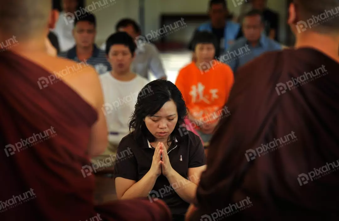 Free Premium Stock Photos A woman sitting in a temple with her eyes closed and her hands clasped in prayer
