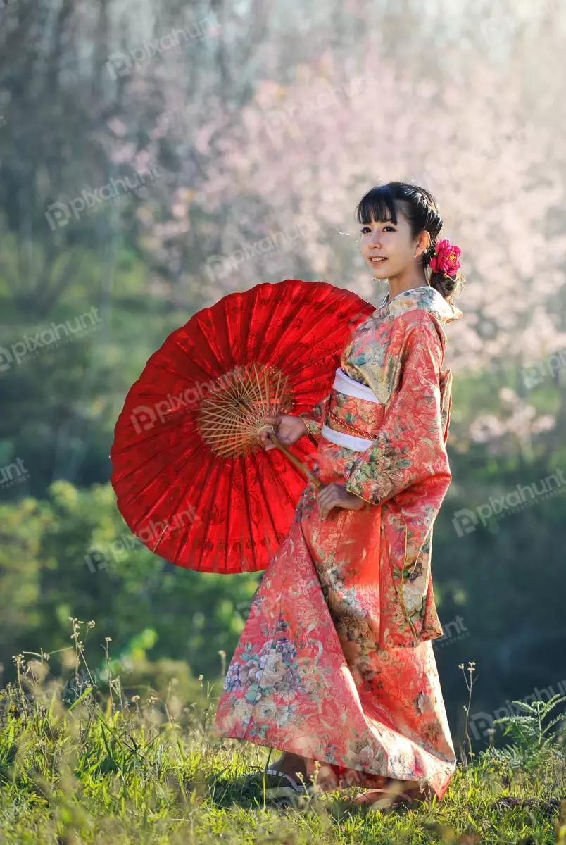 Free Premium Stock Photos A woman wearing a traditional Japanese kimono and hair is dark and long also she is wearing a red flower in her hair
