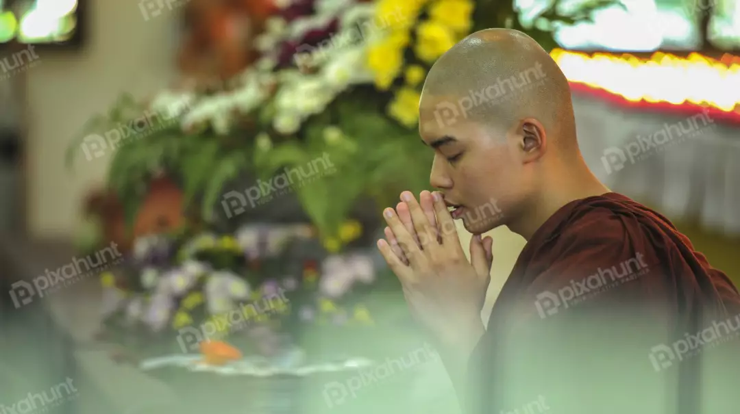Free Premium Stock Photos A young Buddhist monk praying with his eyes closed and his hands together in a prayer position
