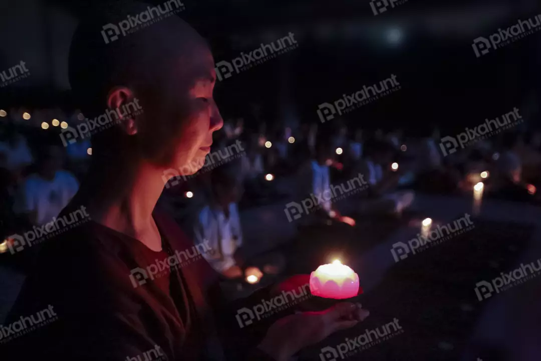 Free Premium Stock Photos A young Buddhist nun holding a candle in her right hand