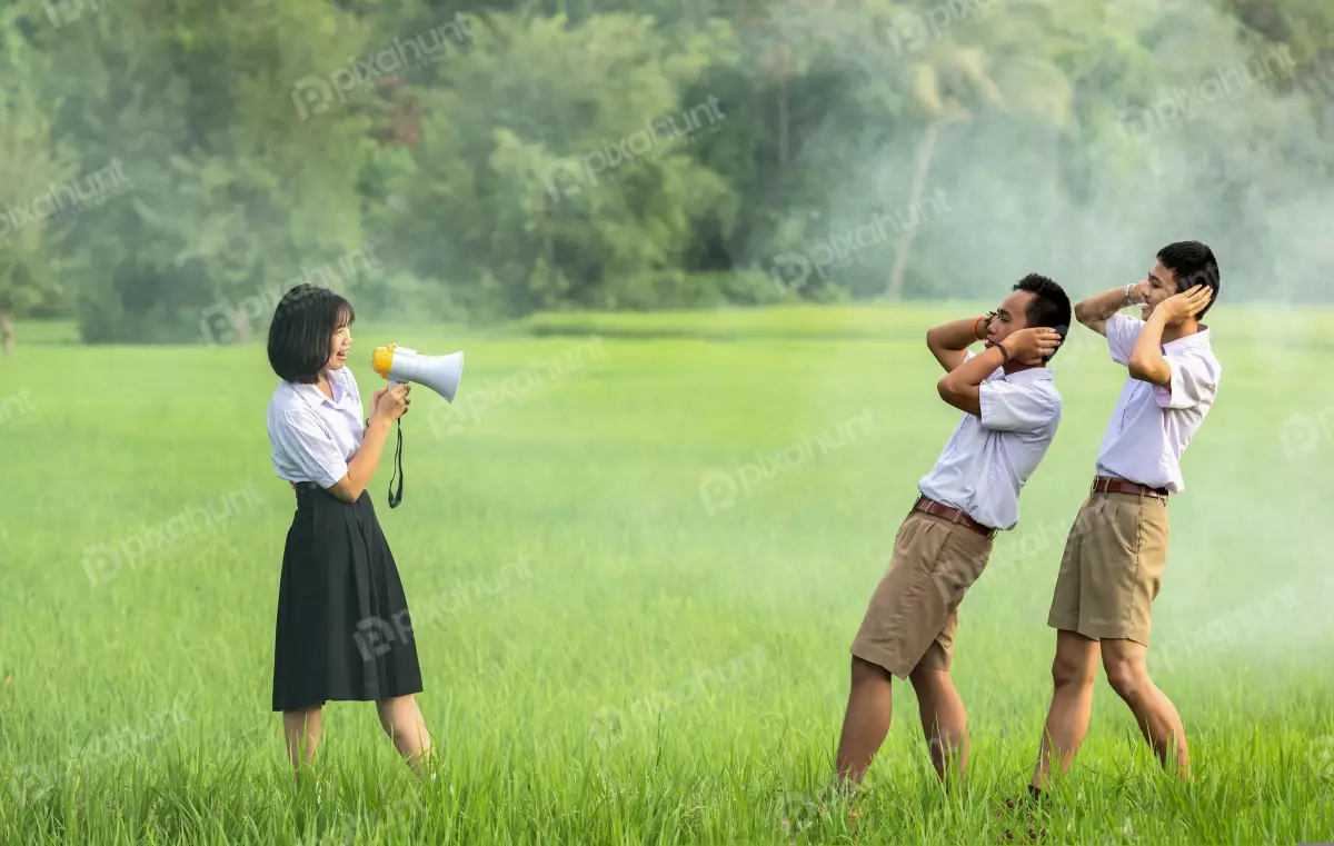 Free Premium Stock Photos A young girl standing in a field, holding a megaphone to her mouth and Announcement for two young men
