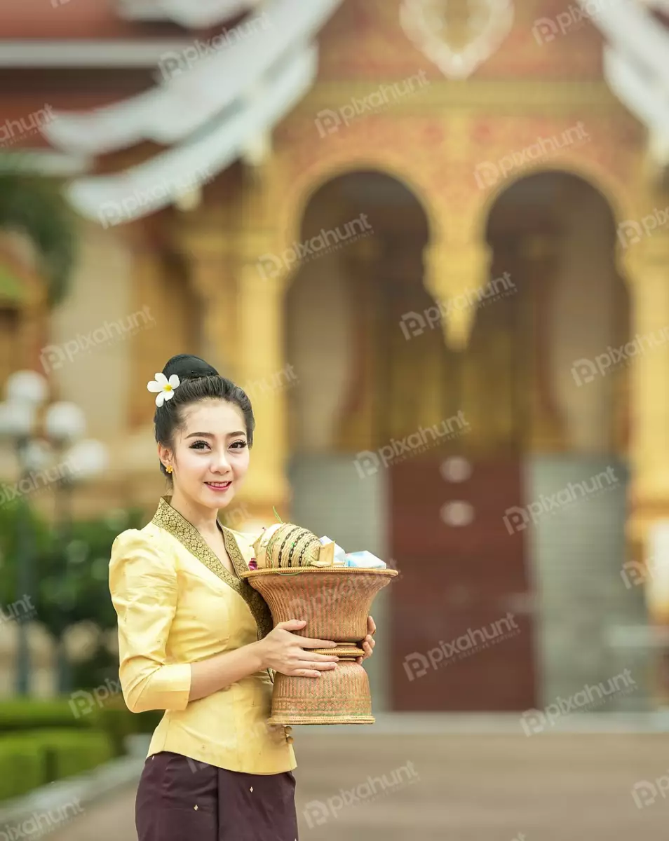 Free Premium Stock Photos A young woman in a traditional Thai outfit And She is standing in front of a temple, with a golden stupa in the background