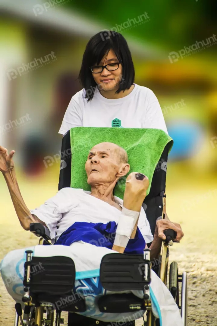 Free Premium Stock Photos A young woman pushing an elderly man in a wheelchair