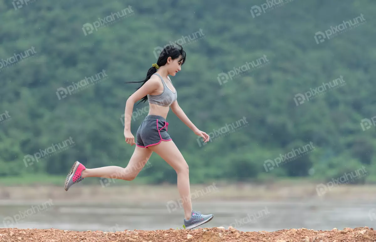 Free Premium Stock Photos A young woman running in a park and wearing a grey sports bra with black shorts