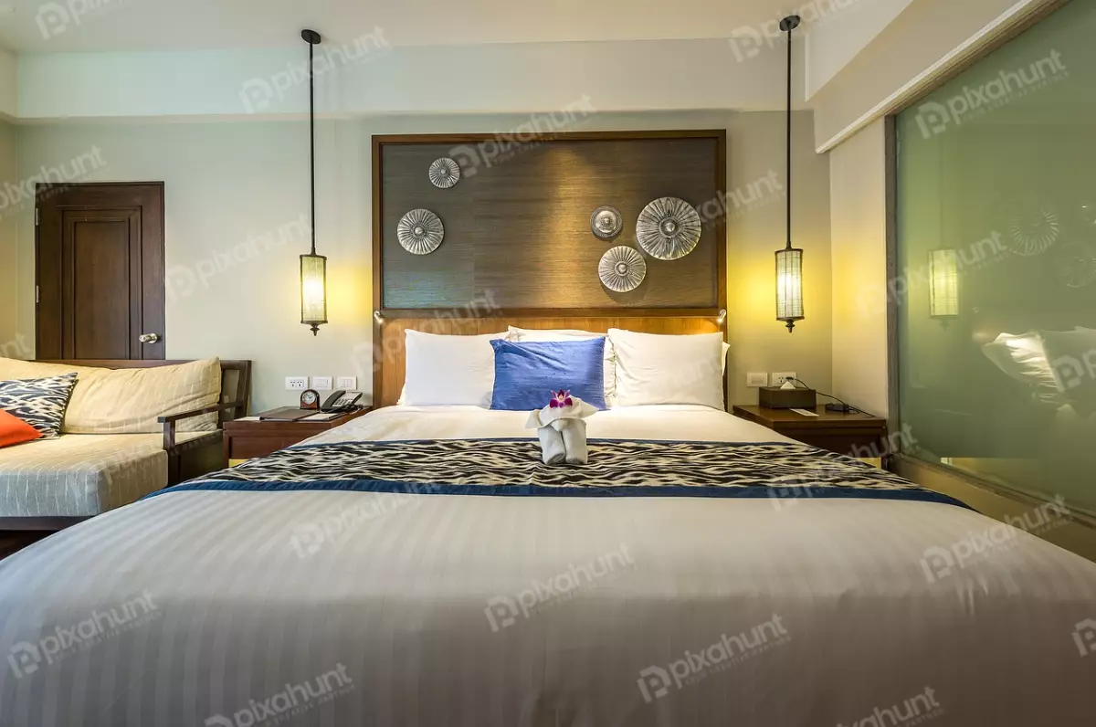 Free Premium Stock Photos Bed is the main focus of the image, and it is covered in a white duvet with a blue and brown striped pattern