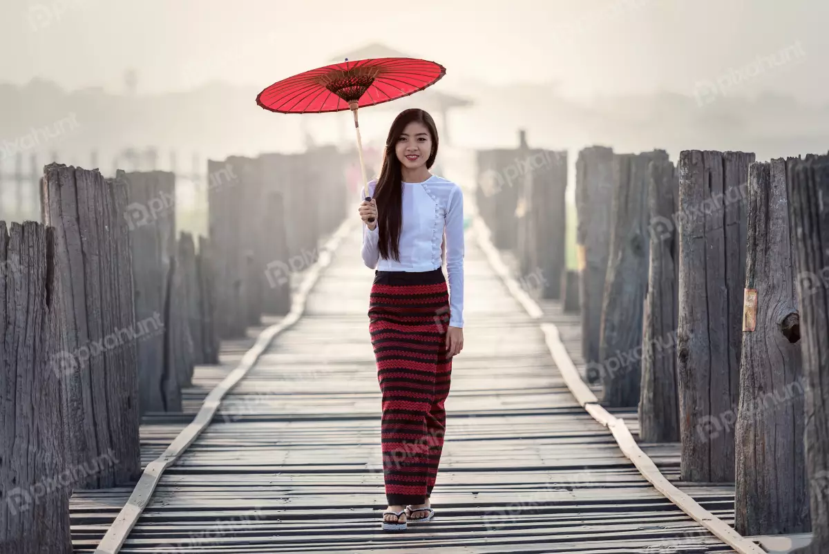 Free Premium Stock Photos Burmese woman in traditional dress walking on a wooden bridge