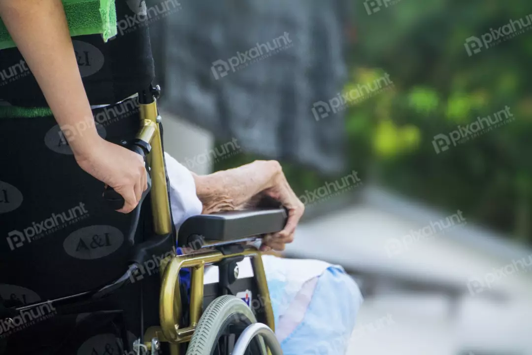 Free Premium Stock Photos Closeup of a sick old man in wheelchair assists by male assistant in front of the hospital in sunny day.