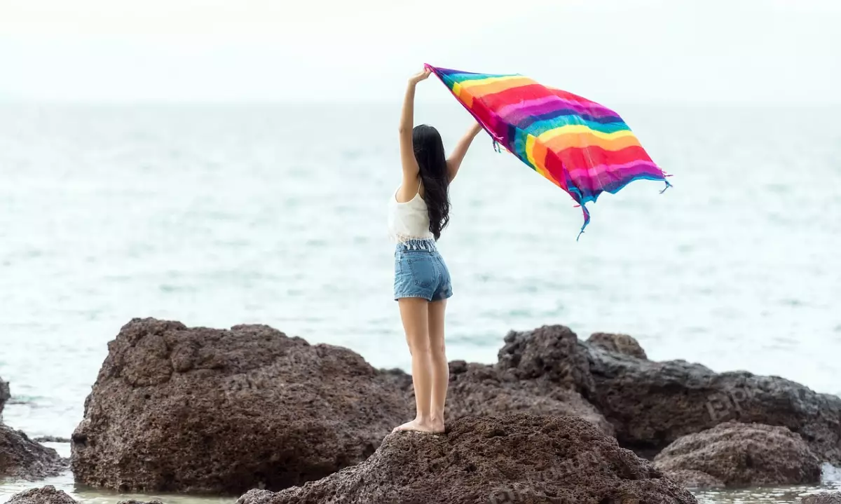 Free Premium Stock Photos girl is wearing a white tank top and blue jean shorts, and she has her arms outstretched to the sides and woman standing on a rock