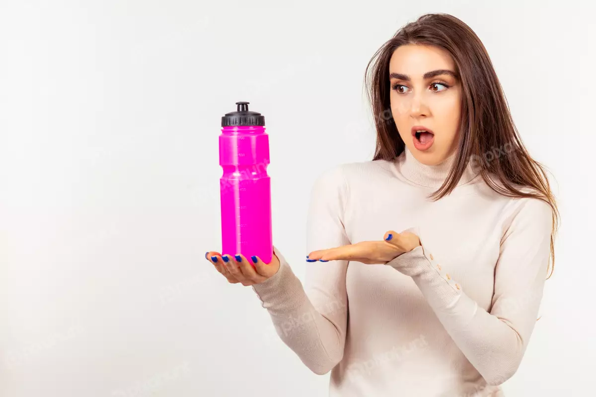 Free Premium Stock Photos Holding Young girl a pink water bottle on point hand at it With Face