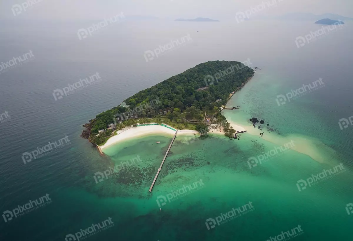 Free Premium Stock Photos island drone view | aerial view of a tropical island is surrounded by a crystal-clear sea and has a lush green forest