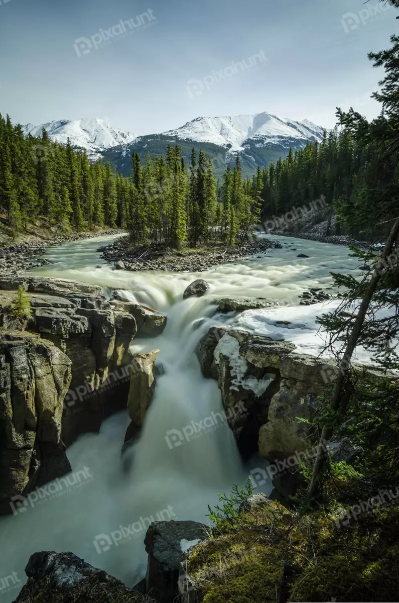 Free Premium Stock Photos looking down at a waterfall and is surrounded by trees and mountains