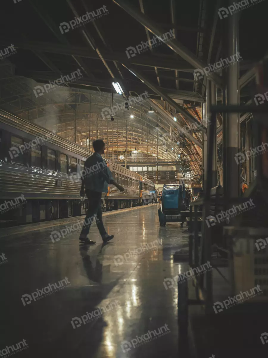 Free Premium Stock Photos Looking up at a man walking away from the camera also center of the frame and the train station is in the background