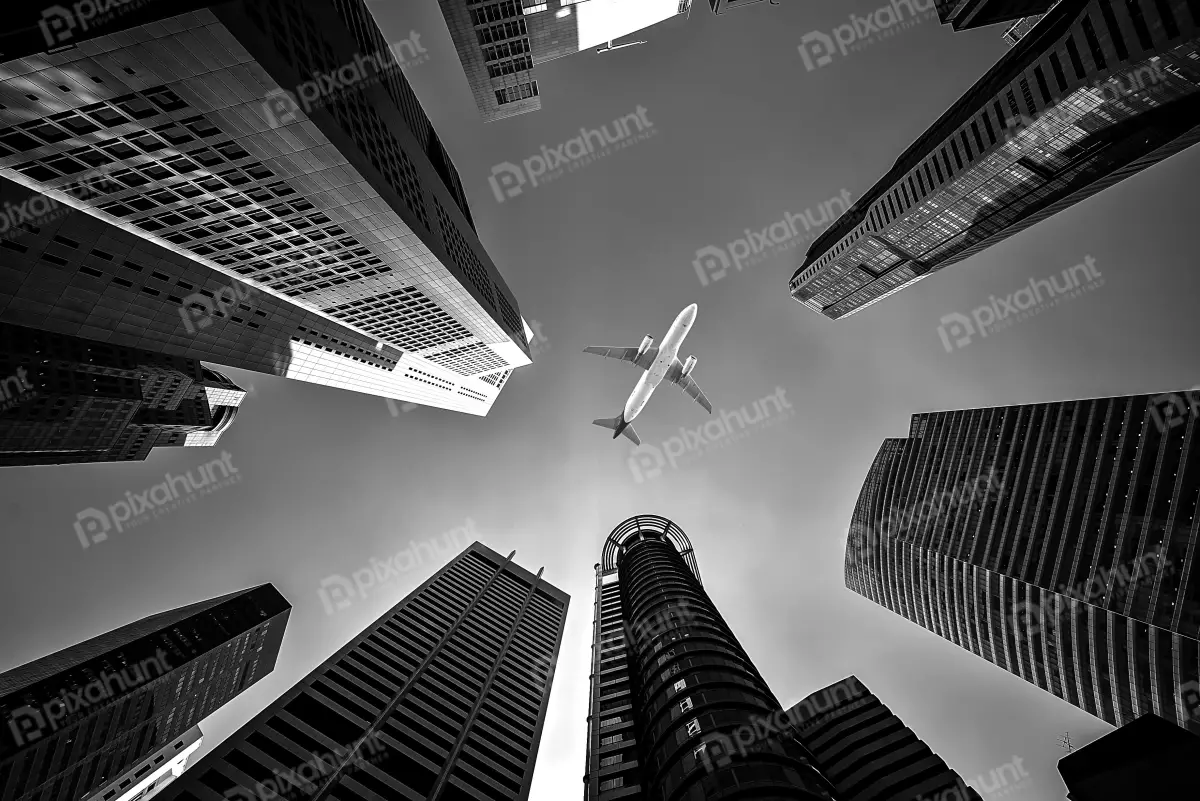 Free Premium Stock Photos looking up at a plane flying directly overhead black and white so the sky seems to be gloomy and grey