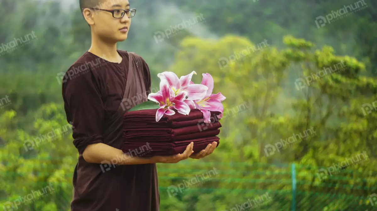 Free Premium Stock Photos Monk Holding A Stack Of Red Cloths With Flower