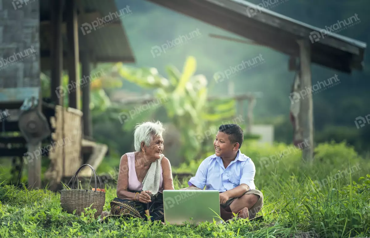 Free Premium Stock Photos old woman and a young boy sitting on the grass in a rural setting