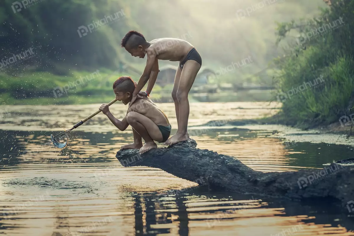 Free Premium Stock Photos Two boys playing in a river with catching fish and boys are both shirtless and wearing shorts