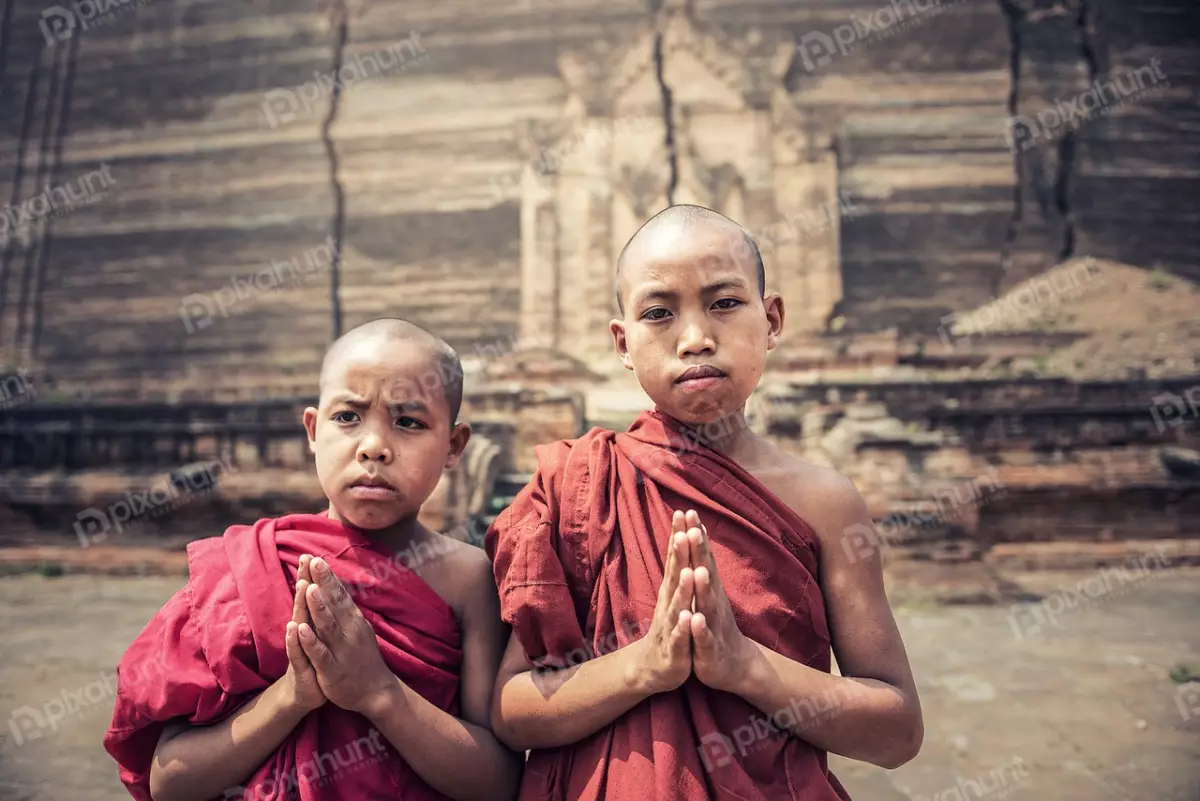 Free Premium Stock Photos Two Buddhist monks standing in front of a temple and both wearing red robes and have their heads shaved