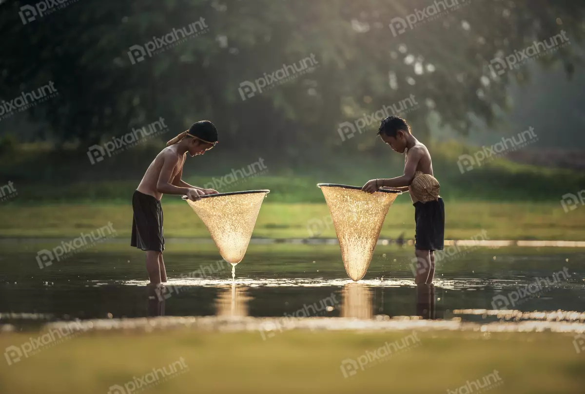 Free Premium Stock Photos Two little boys fishing in a river and boys are both wearing shorts and no shirts, and they are both standing in the water