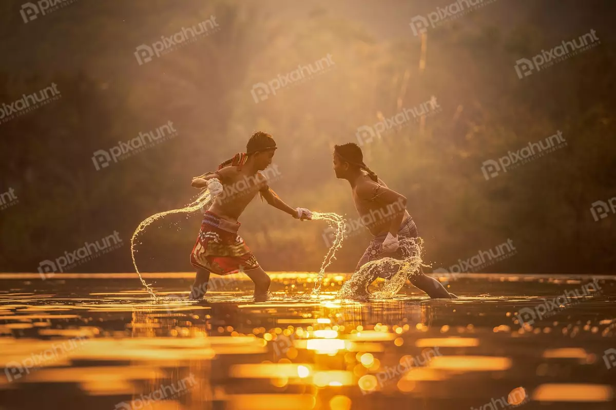 Free Premium Stock Photos Two men engaged in a Muay Thai fight in a river and water is shallow, the men are standing about waist-deep