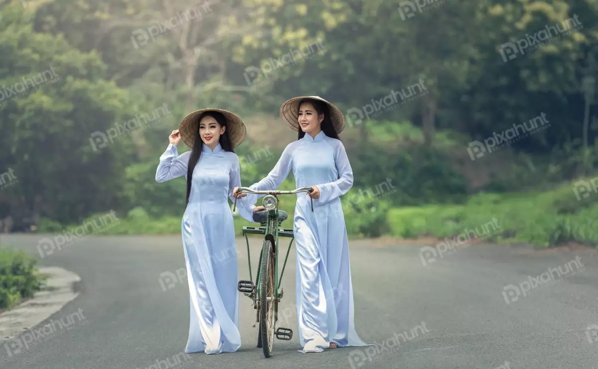 Free Premium Stock Photos Two Vietnamese women in traditional ao dai dresses walking on a road