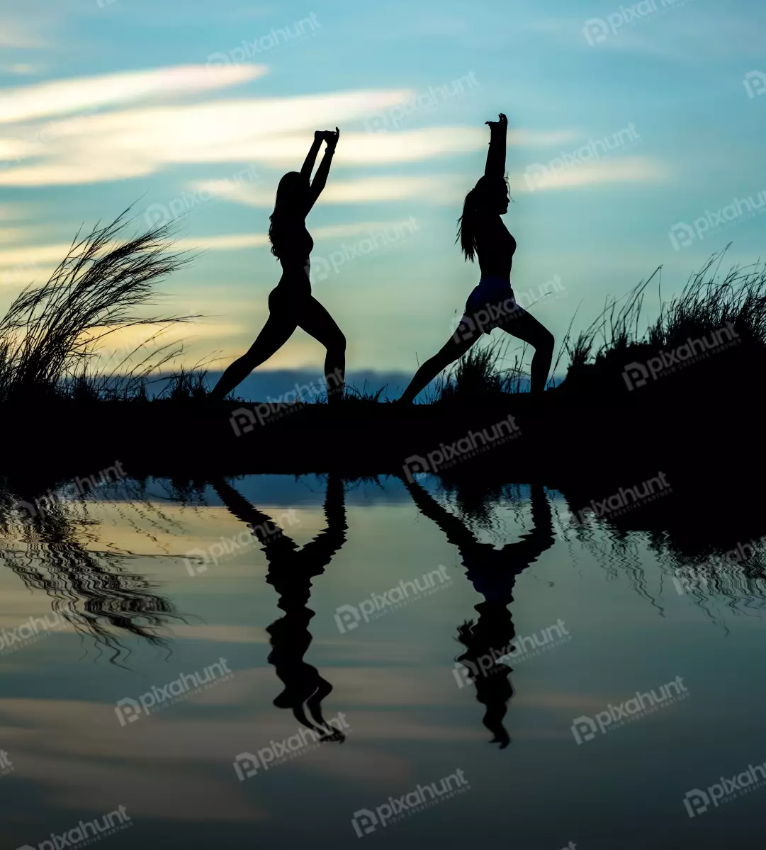 Free Premium Stock Photos Two women doing yoga on a beach at sunset