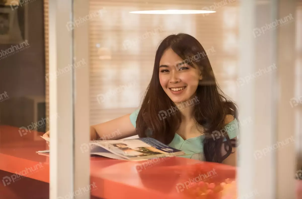 Free Premium Stock Photos Woman sitting at a table in a coffee shop and smiling and looking at the camera