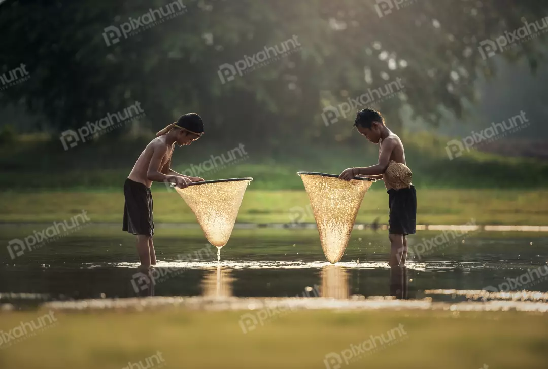 Free Premium Stock Photos Two little boys fishing in a river and boys are both wearing shorts and no shirts, and they are both standing in the water