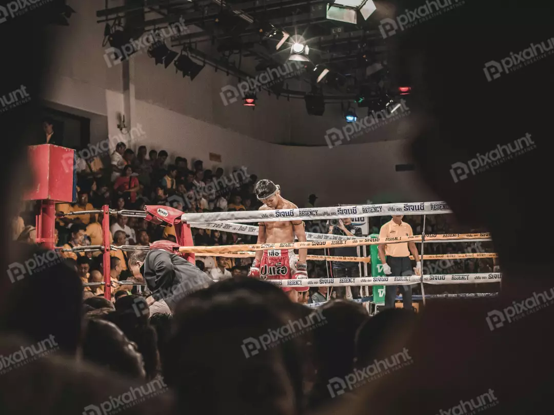 Free Premium Stock Photos A Muay Thai boxing match with fighters are in the ring and the referee is standing in between them