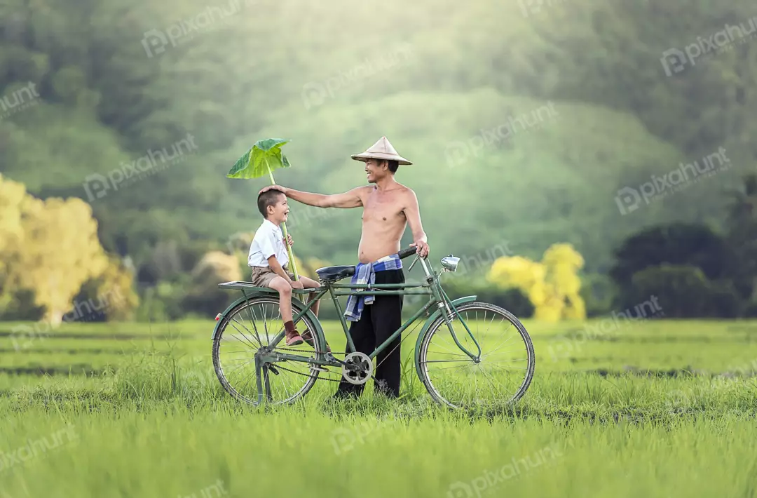 Free Premium Stock Photos Happy moment between a father and son and father is holding a leaf over his son's head to protect him from the sun