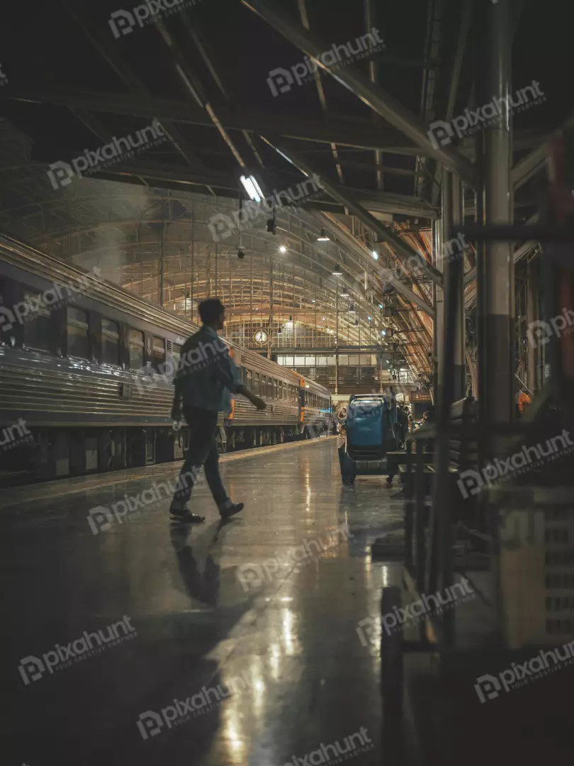 Free Premium Stock Photos Looking up at a man walking away from the camera also center of the frame and the train station is in the background