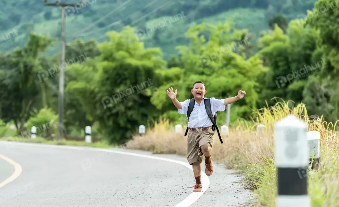 Free Premium Stock Photos A boy running down a road and wearing a school uniform and has a backpack on his back