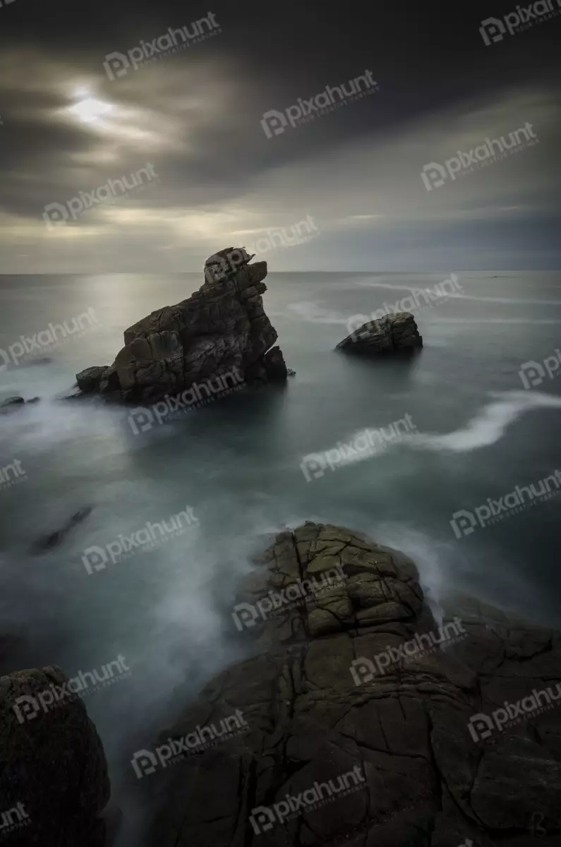 Free Premium Stock Photos looking up at a large rock in the middle of the ocean