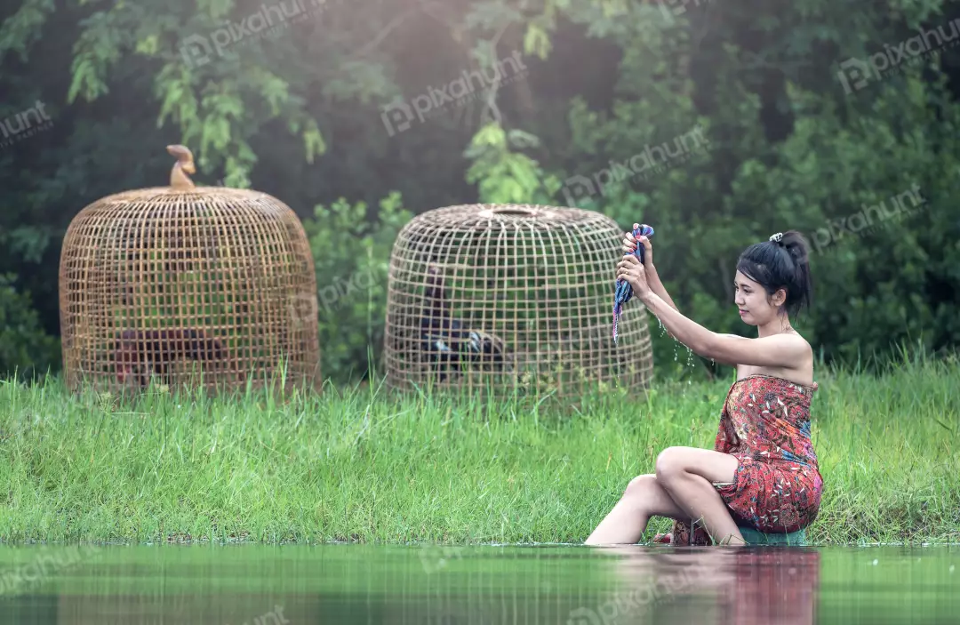 Free Premium Stock Photos Woman look larger than life and sitting on a rock in the middle of a river with her feet in the water