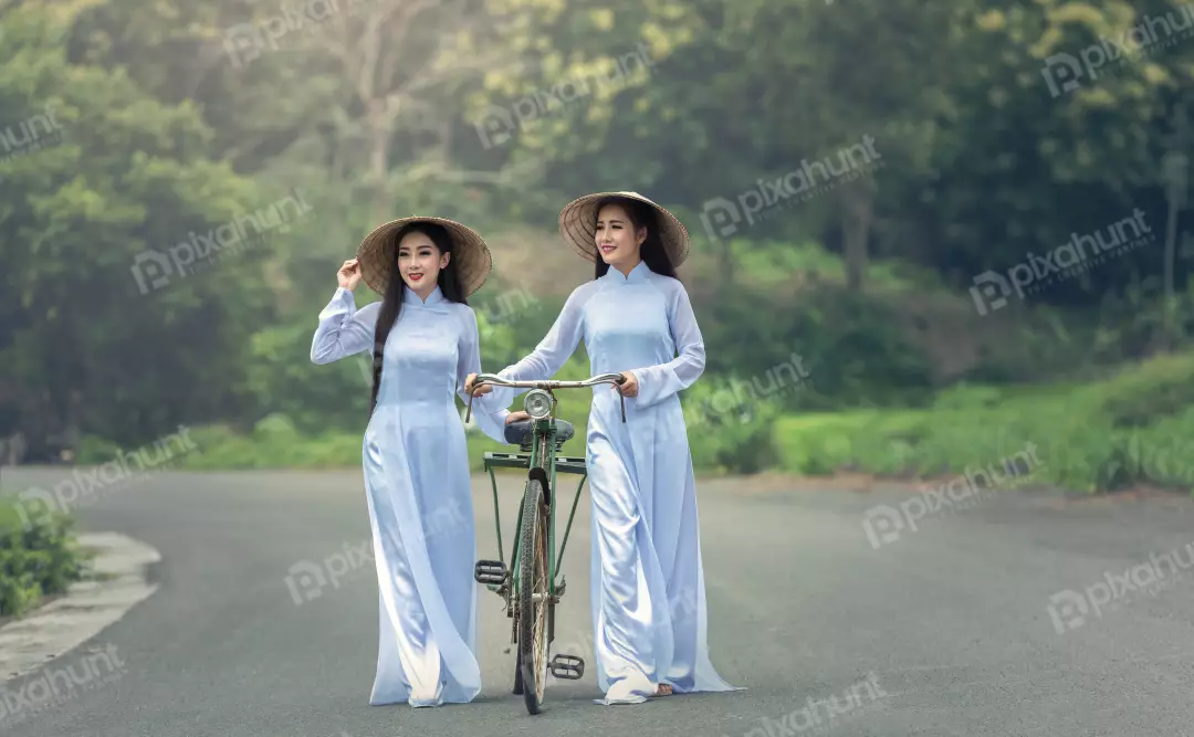 Free Premium Stock Photos Two Vietnamese women in traditional ao dai dresses walking on a road