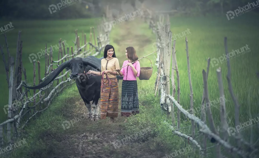 Free Premium Stock Photos Two girls in a field walking towards the camera One woman is wearing a pink shirt and a long skirt, and the other is wearing a blue shirt and a long skirt