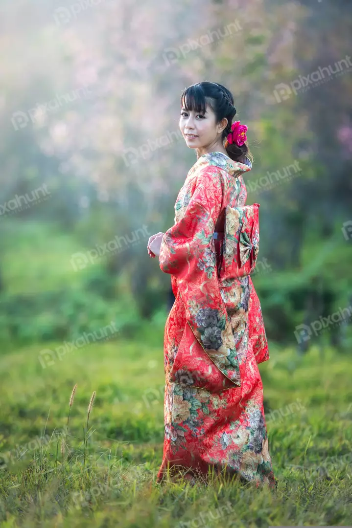 Free Premium Stock Photos A beautiful woman wearing a traditional Japanese kimono and long black hair is tied in a bun and she has a pink flower in her hair