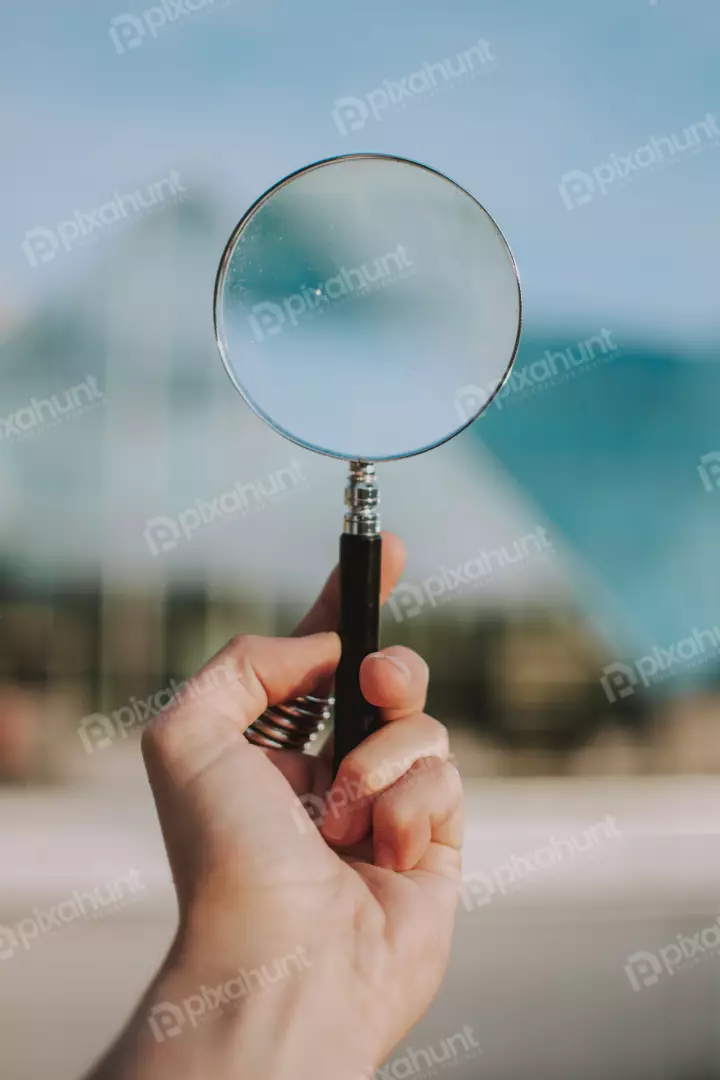 Free Premium Stock Photos a hand holding a magnifying glass