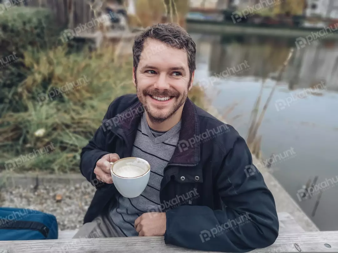 Free Premium Stock Photos Healthy Man is sitting on a bench with a cup of coffee in his hand