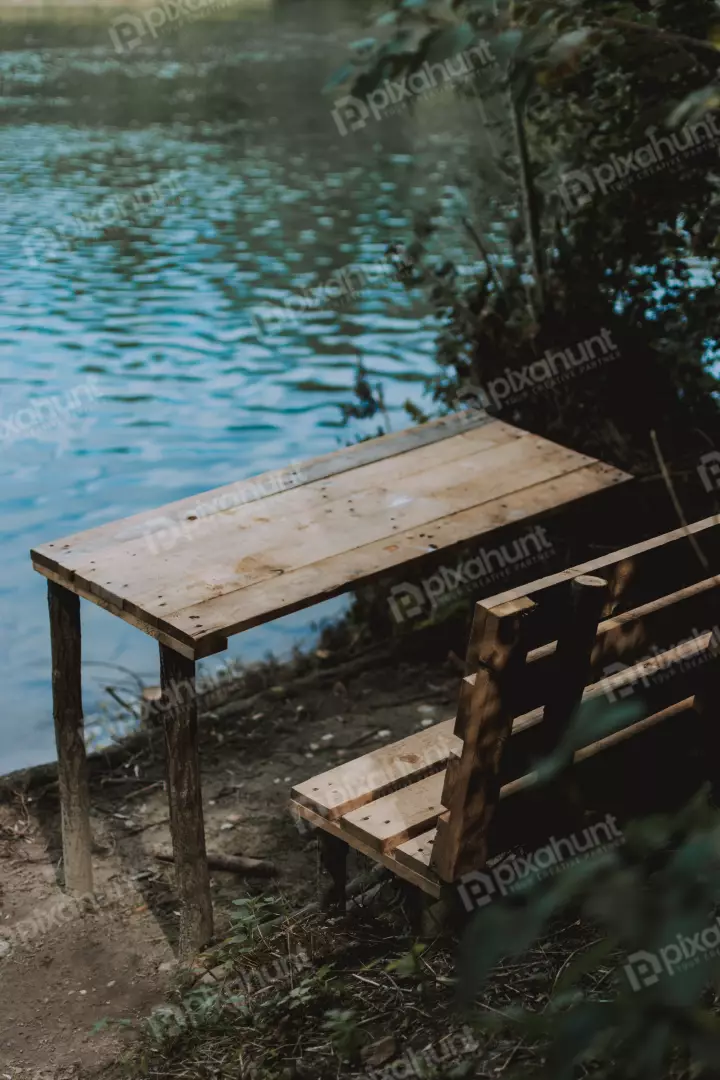 Free Premium Stock Photos a beautiful landscape of a lake with a wooden table and bench in the foreground