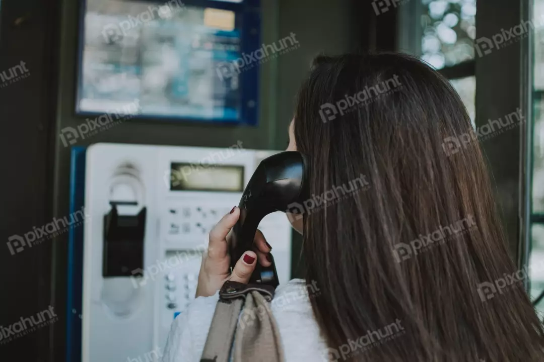 Free Premium Stock Photos Woman is standing in a phone booth, and she is holding the phone to her ear