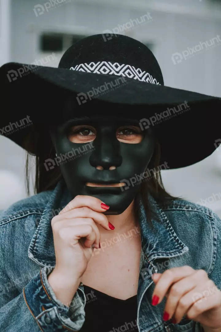 Free Premium Stock Photos A woman wearing a black hat and a black mask