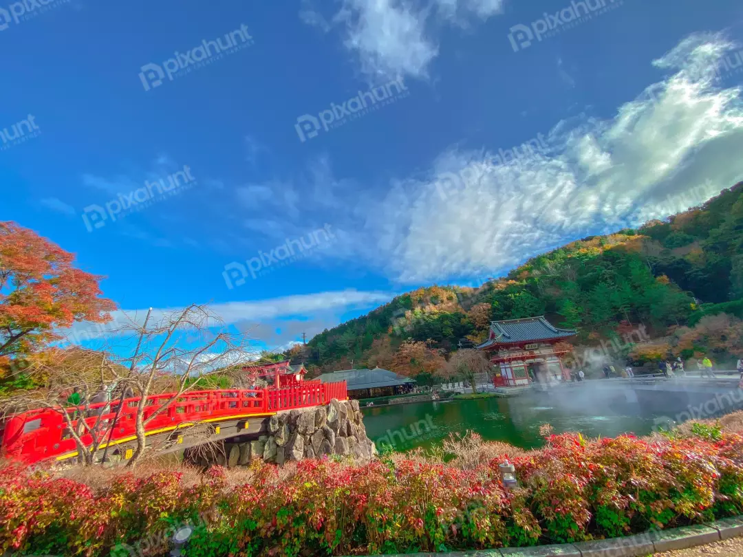 Free Premium Stock Photos a beautiful Japanese garden with a red bridge, a pond, and a traditional Japanese house