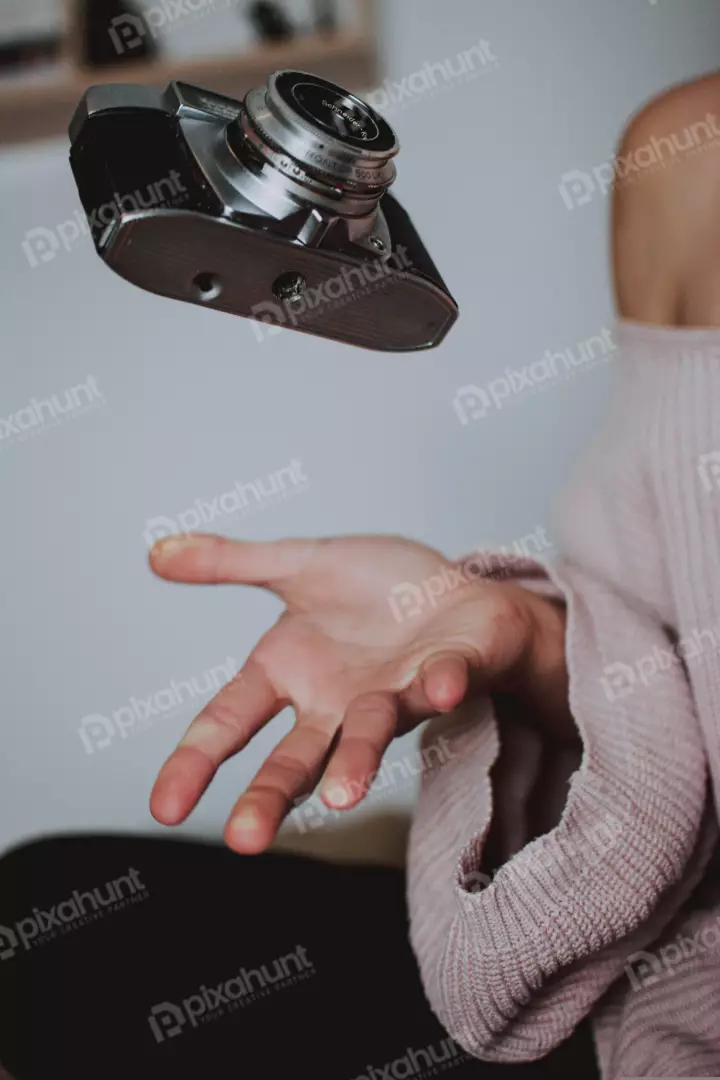 Free Premium Stock Photos a vintage camera floating above a woman's hand