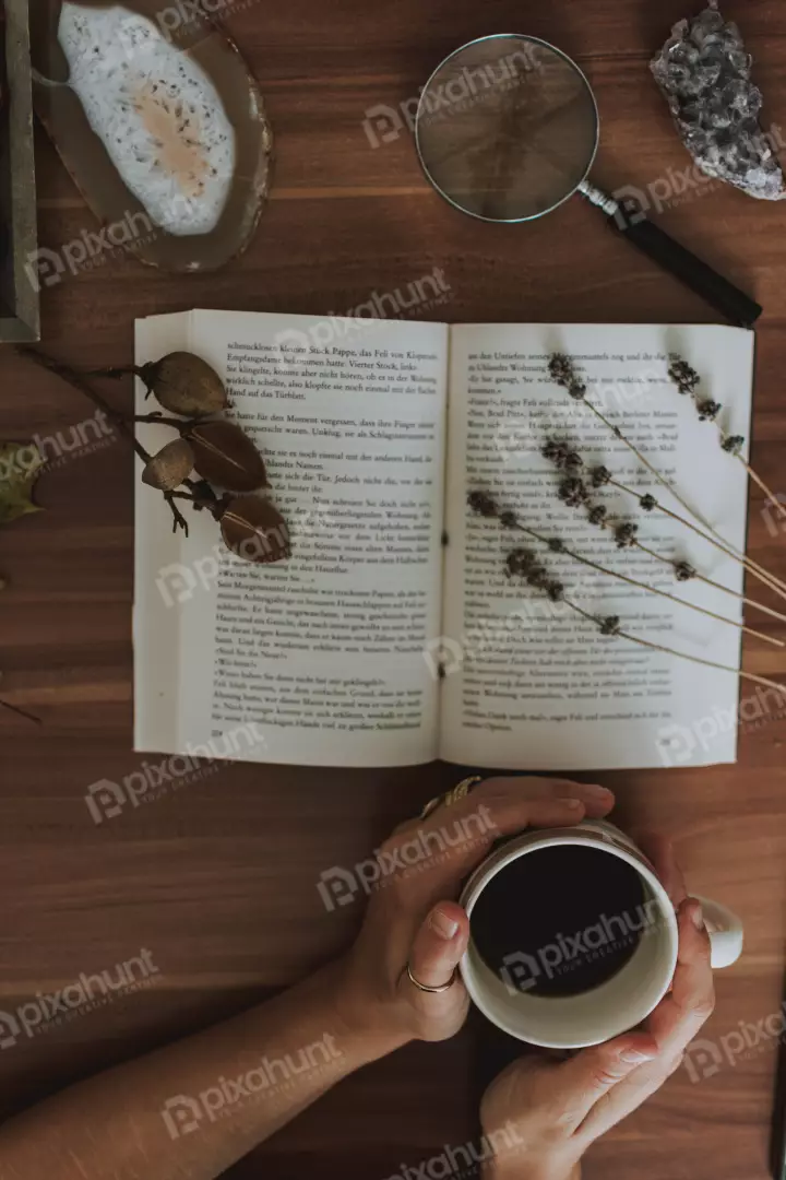 Free Premium Stock Photos a flat lay of a book, a cup of coffee, a magnifying glass, a rock, a leaf, and some other objects on a wooden table