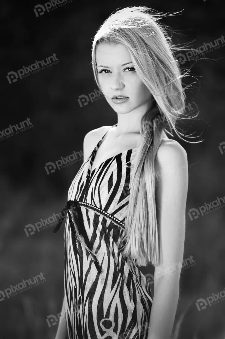 Free Premium Stock Photos Black and white portrait of a young woman is standing in front of a dark background, and her face is turned slightly to the left